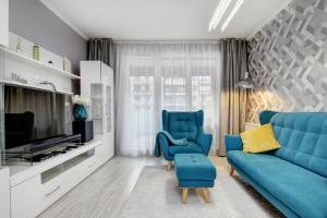 uma sala de estar com um sofá azul e uma televisão em Vision Apartments Budapest Exclusive em Budapeste