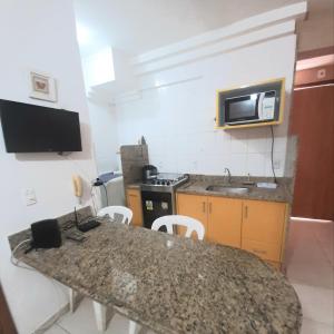 uma cozinha com um balcão, um lavatório e um micro-ondas em Flats Bueno em Goiânia em Goiânia