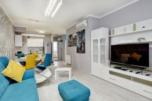 - un salon avec un canapé bleu et des fauteuils jaunes dans l'établissement Vision Apartments Budapest Exclusive, à Budapest