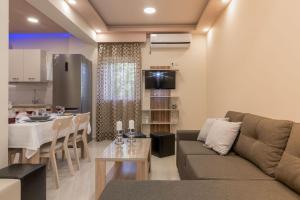 ein Wohnzimmer und eine Küche mit einem Sofa und einem Tisch in der Unterkunft Zante Sky Suites in Argassi