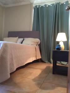 1 dormitorio con 1 cama y 1 mesa con lámpara en Korallen Haus, en Nicoya