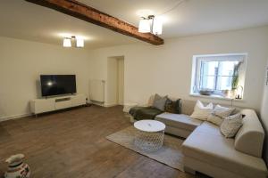 a living room with a couch and a flat screen tv at Ferienhaus Theodor EG in Laufen