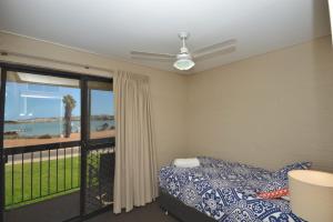 ein Schlafzimmer mit Bett und Blick auf das Meer in der Unterkunft Riverview Holiday Apartment 11 - Kalbarri, WA in Kalbarri