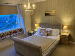 a bedroom with a large bed and a window at Shorelands B&B in Kirkwall