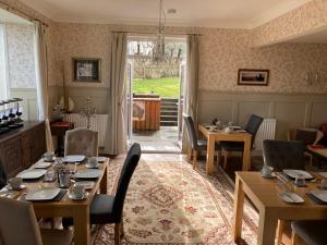 een eetkamer met tafels en stoelen en een raam bij Shorelands B&B in Kirkwall