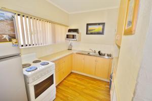 a small kitchen with a stove and a sink at Riverview Holiday Apartment 12 - Kalbarri WA in Kalbarri