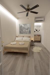 1 dormitorio con 1 cama y ventilador de techo en Little Suite, en Porto Empedocle