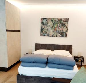 a bed with blue pillows in a room at MAISON MY LIFE in Bolzano