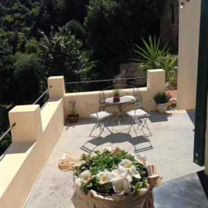 uma varanda com mesa, cadeiras e flores em B&B Lacrêma em Finale Ligure