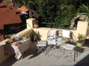 uma mesa e cadeiras com comida numa varanda em B&B Lacrêma em Finale Ligure