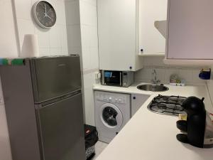 a kitchen with a refrigerator and a washing machine at Apartamento la Ribera in Suances