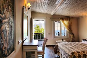 a bedroom with a bed and a desk and a window at Losta Sahil Evi - Adults Only +12 in Selimiye +65 photos