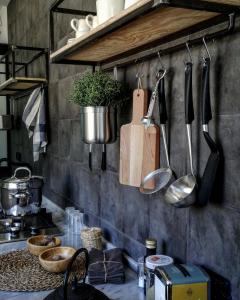 una encimera de cocina con utensilios colgando de una pared en Little Suite, en Porto Empedocle