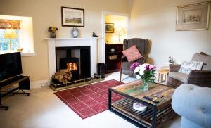 Mill Cottage في فورس: غرفة معيشة مع موقد وأريكة