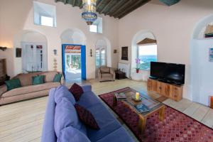 a living room with a blue couch and a tv at Lilly's Home -2 Bedrooms in Mýkonos City