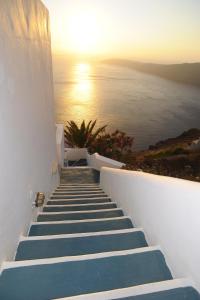 a row of stairs leading up to a balcony overlooking the ocean at Prekas Apartments in Imerovigli