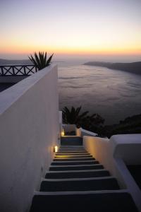 a set of stairs with a sunset in the background at Prekas Apartments in Imerovigli