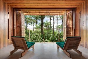 Duas cadeiras num quarto com uma grande janela em Barracuda Hotel & Villas em Itacaré