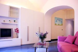 a living room with a pink couch and a table at Ischia Domus in Ischia