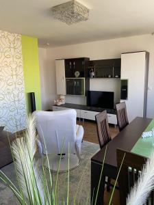 ein Wohnzimmer mit einem weißen Stuhl und einem Tisch in der Unterkunft Ferienwohnung Mainz Stadt in Mainz