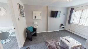 a living room with a black chair and a table at Marina House in Hull +2 photos