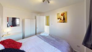 a bedroom with a white bed with red pillows at Marina House in Hull