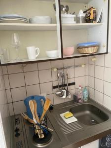 Appartement Universität Mainz في ماينز: مغسلة المطبخ بجانبها كرسي ازرق