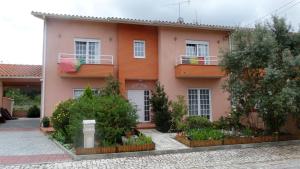 une maison rose avec des plantes devant elle dans l'établissement Casa Nana, à Cadima