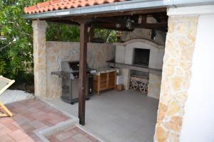 a patio with an outdoor kitchen with a stone wall at Apartment Mary in Trogir