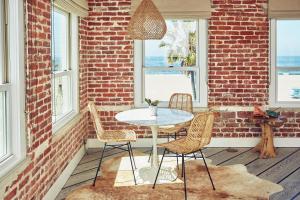 a table and chairs in a room with a brick wall at Venice V Hotel in Los Angeles