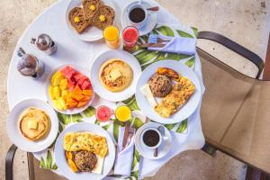 una mesa blanca con desayuno y bebidas. en Miradas Arenal Hotel & Hotsprings, en Fortuna