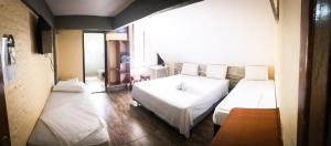 a bedroom with two beds and a large window at Pousada Solarium-UNIDADE 2 - HOTEL BOUTIQUE in Guarujá +72 photos