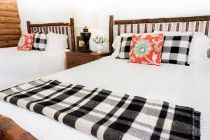 two beds with black and white pillows in a bedroom at Kedron Valley Inn in Woodstock