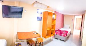a small room with a desk and a bed and a table at Pousada Solarium-UNIDADE 2 - HOTEL BOUTIQUE in Guarujá