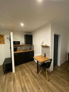 uma cozinha com uma mesa de madeira e uma sala de jantar em Apartmán Ginko I em Koliba