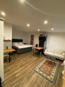 ein Schlafzimmer mit einem Bett, einem Sofa und einem Tisch in der Unterkunft Apartmán Ginko I in Koliba