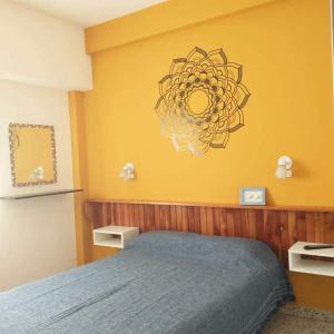 a bedroom with a blue bed and a yellow wall at Hostería Altea in Monte Hermoso