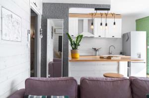 eine Küche und ein Wohnzimmer mit lilafarbenen Möbeln in der Unterkunft Appartement Barcares Village VUE MER in Le Barcarès