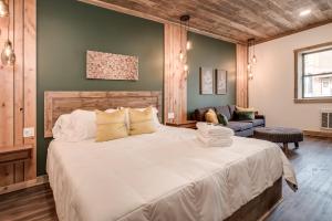 uma grande cama branca num quarto com um sofá em The Port of Prescott Boutique Hotel em Prescott