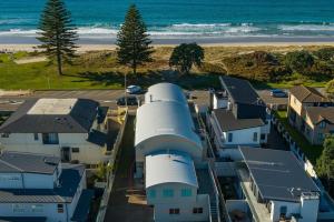 an aerial view of a house with a beach at Modern Marine Parade Apartment in Mount Maunganui