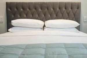 a bed with two pillows on top of it at Modern Marine Parade Apartment in Mount Maunganui