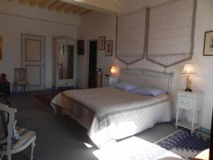 sypialnia z dużym łóżkiem i krzesłem w obiekcie Château Du Bois Glaume w mieście Poligné