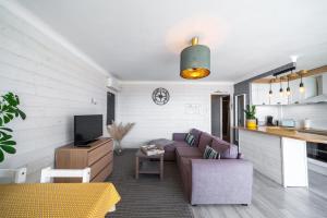 ein Wohnzimmer mit einem Sofa und einem TV in der Unterkunft Appartement Barcares Village VUE MER in Le Barcarès