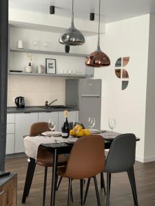 a kitchen with a table with chairs and wine glasses at Central Apartments Апартаменти в центрі in Khmelʼnytsʼkyy