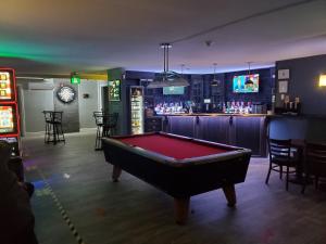 Newfound Inn & Suites في Topsail: طاولة بلياردو في غرفة مع بار