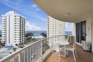 a balcony with a table and chairs and a view of the ocean at Moroccan Resort - HR Surfers Paradise in Gold Coast