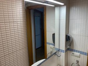 Apartamento Ría Punta Umbría في بونتا أومبريا: حمام مع مرآة كبيرة ومغسلة