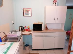 eine Küche mit weißen Schränken und einer Mikrowelle in der Unterkunft Sea & Lakes self-catering in Wilderness