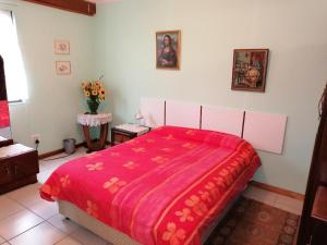 ein Schlafzimmer mit einem Bett mit einer roten Decke in der Unterkunft Sea & Lakes self-catering in Wilderness