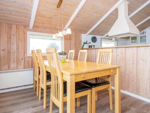 a dining room with a wooden table and chairs at 6 person holiday home in R m in Bolilmark